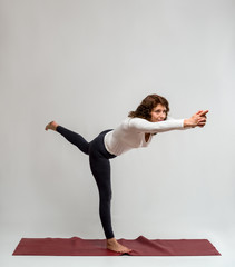 Studio shot of a woman doing yoga exercises on white background