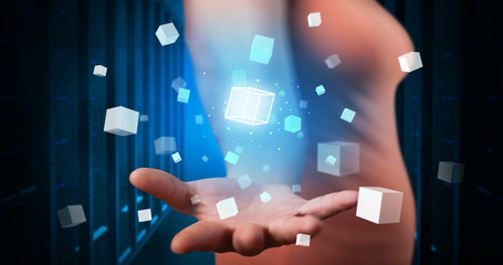 Person holding hologram projection displaying white cubes in server room
