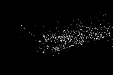 Split debris of stone exploding against black background.