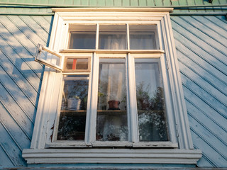The window is wooden in a wooden house.
