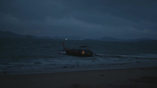 Boat drifting in the wavy sea  over cloudy dark sky background. Cinematic dramatic footage of restless sea water and sky before the storm in early morning