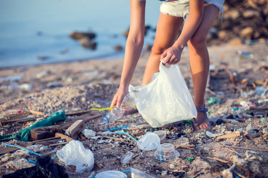 Woman Collect Garbage On The Beach. Environmental Pollution Concept