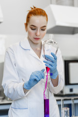 Fototapeta premium red-haired woman works in the medical laboratory