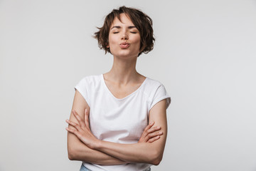 Obraz premium Image of beautiful woman in basic t-shirt looking at camera while standing with arms crossed