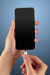 Close-up view of hand charging smartphone