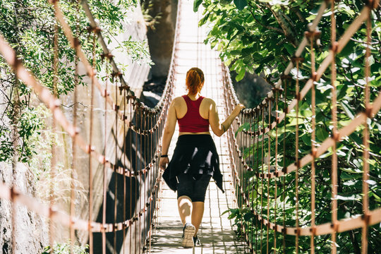 Young woman on a suspension bridge walking on the Los Cahorros route, Granada, Spain