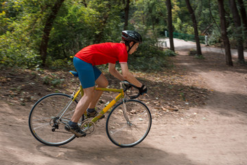 Naklejka premium A cyclist rides on a road bicycle, coming down hill.