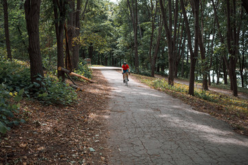 Obraz premium A cyclist rides on a road bicycle on road in woods.