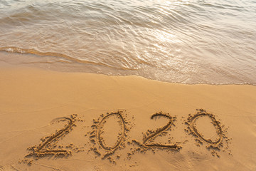 New year 2020 on sandy beach with waves
