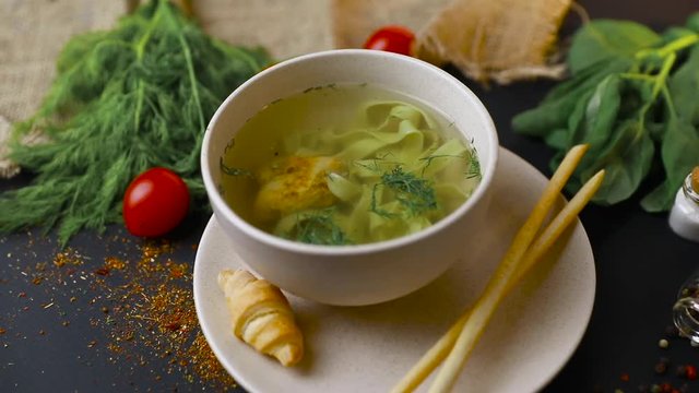 Chicken and potato chowder soup with green bell pepper and carrot in bowls. Healthy food, top view. Black background . Slow-mo