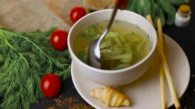 Chicken and potato chowder soup with green bell pepper and carrot in bowls. Healthy food, top view. Black background . Slow-mo