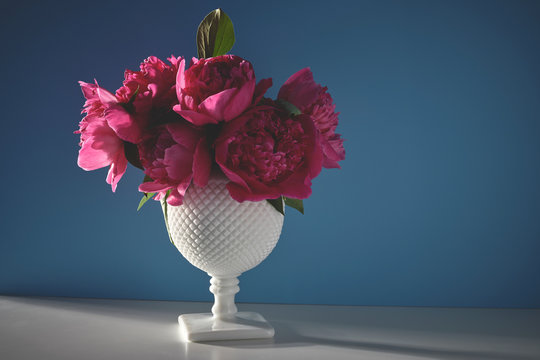 a vintage vase with a bouquet of pink peony flowers