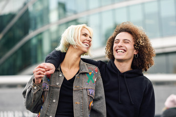 Happy young couple laughing in urban background
