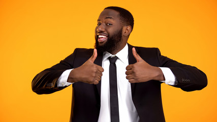 Happy afro-american businessman making double thumbs-up gesture, recommendation