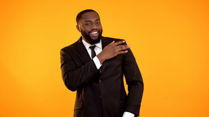 Confident black businessman shaking dust of formal suit, dry cleaning services