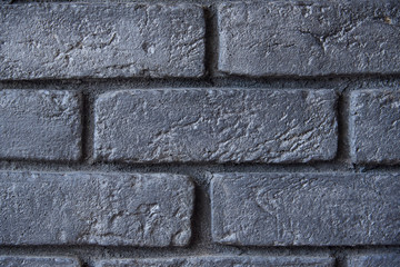Fragment of a brick wall. The wall is painted black. Background