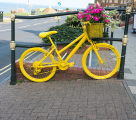 Fototapeta na wymiar Yellow painted old fashioned bicycle on display