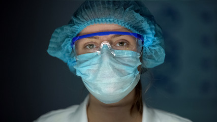 Scientist in protective uniform looking to camera, tired doctor after surgery