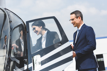 businessman opening door of helicopter for smiling businesswoman © LIGHTFIELD STUDIOS