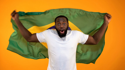 African-American man holding Brazilian flag, supporting national sports team