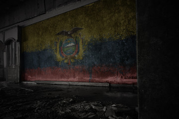 Fototapeta na wymiar painted flag of ecuador on the dirty old wall in an abandoned ruined house