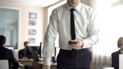 Angry businessman holding cellphone, worrying about problems at work, overwork