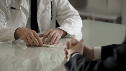 Patient paying dollars cash to doctor for expensive operation, medical reform