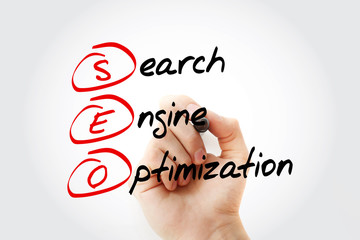 Hand writing SEO (Search Engine Optimization) with marker, business concept