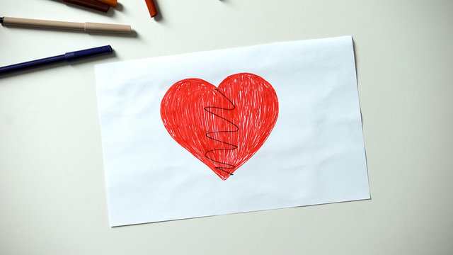Broken heart drawing lying on table, divorce and family problems concept