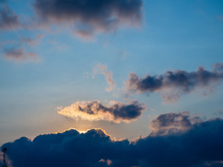 The sun behind the clouds on the horizon. Silhouettes of hills with palm trees Thailand