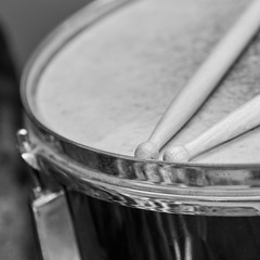 Obraz premium Wooden drumsticks lie on the drum, black and white photo