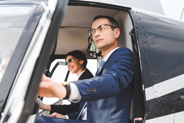 businesswoman and businessman sitting in helicopter cabin