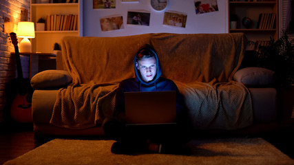 Teenager surfing internet on laptop, visiting gambling sites, young hacker © motortion