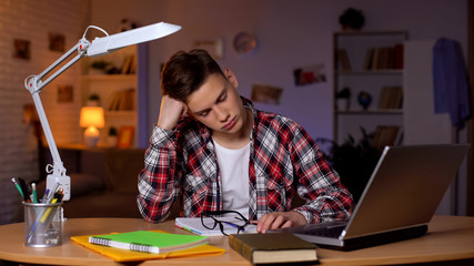 Exhausted student napping preparing for exams late at night, lack of energy