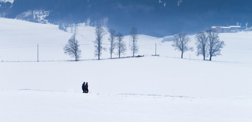 TYROL, AUSTRIA - CIRCA 2017: Two men walks in the snow at winter circa 2017 in Tyrol.