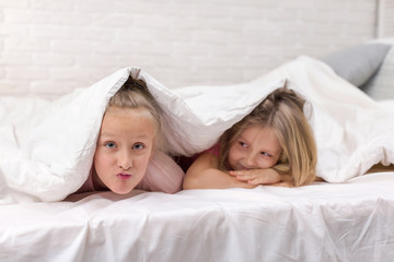 Obraz na płótnie Canvas happy smiling morning kids in bed. children dabble in bed