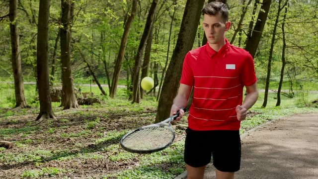 Man Beats The Tennis Ball From The Racket. Young Person Playing Tennis. A Person Dressed In A Red T-shirt And Black Shorts. Prores, Slow Motion, 4k