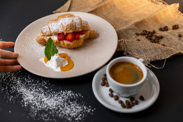 Breakfast with fresh croissants, cup of coffee and strawberry jam on a Black background, Slow-mo