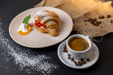 Breakfast with fresh croissants, cup of coffee and strawberry jam on a Black background, Slow-mo