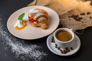 Breakfast with fresh croissants, cup of coffee and strawberry jam on a Black background, Slow-mo