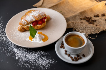 Breakfast with fresh croissants, cup of coffee and strawberry jam on a Black background, Slow-mo