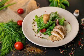Healthy Grilled Chicken Caesar Salad with Cheese and Croutons. Healthy food, top view. Black background . Slow-mo