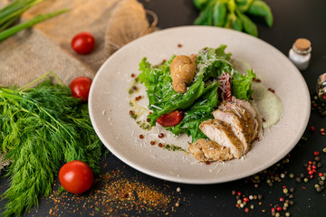 Healthy Grilled Chicken Caesar Salad with Cheese and Croutons. Healthy food, top view. Black background . Slow-mo