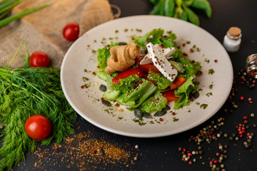 Greek salad of fresh cucumber, tomato, sweet pepper, lettuce, red onion, feta cheese and olives with olive oil. Healthy food, top view. Black background . Slow-mo.
