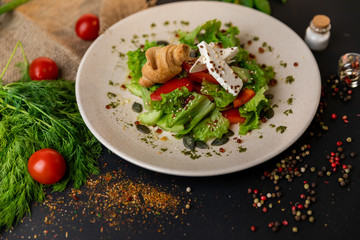 Greek salad of fresh cucumber, tomato, sweet pepper, lettuce, red onion, feta cheese and olives with olive oil. Healthy food, top view. Black background . Slow-mo.