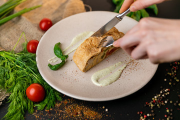 Large portion of healthy colorful vegetable lasagne made with assorted fresh veggies layered with melted mozzarella and pasta served on a white plate. Black background . Slow-mo