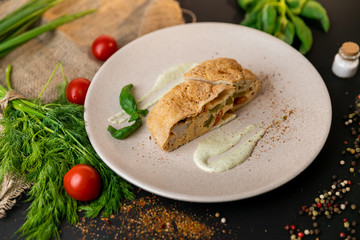 Large portion of healthy colorful vegetable lasagne made with assorted fresh veggies layered with melted mozzarella and pasta served on a white plate. Black background . Slow-mo