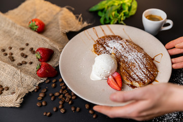Tasty breakfast. Closeup of pancakes with fresh fruits, ice cream and whipped cream. Black background. Slow-mo.