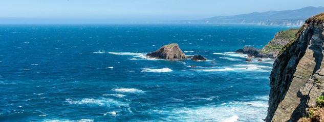 waves running against the cliffs of Cabo Busto on a stormy day at the coast of the Bay of Biscay