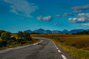 Girl in blue dress laying on the road  in  Straumnes